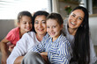 © Halfpoint - Happy small girls with mother and grandmother indoors at home, sitting on floor and looking at camera