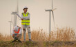 © kokotewan - Two Asian engineers or technician men in uniform  acting Wind turbines ecological energy industry power windmill field worker renewable background.