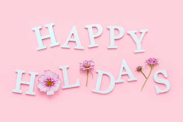Wall Mural - Happy holidays. Motivational quote from white letters and beauty natural flowers on pink background. Creative concept inspirational quote