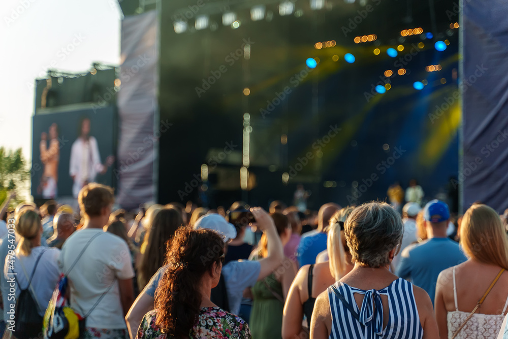 People watching music concert on large stage. Stock Photo | Adobe