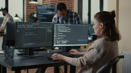 focused software developer writing code looking at multiple computer screens displaying machine lear
