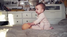 Cute Chubby Baby Play With A Doll On The Bed In The Bedroom, Identical Toddler And Doll