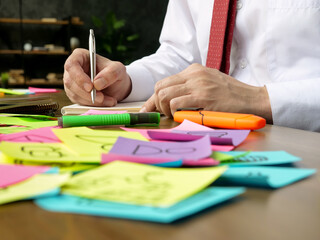 Poster - The manager works with papers at the table. Lots of multicolored stickers.