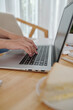 © DragonImages - Hands of female freelancer typing on laptop