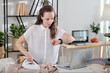 © DragonImages - Businesswoman ironing clothes and checking messages on smartwatch and laptop