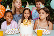 © Drobot Dean - White happy girl in party cone celebrating birthday with her friends