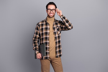 Wall Mural - Photo of smart clever man wear plaid shirt arm spectacles holding modern gadget isolated grey color background