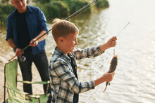 Showing The Catch. Father And Son On Fishing Together Outdoors At Summertime