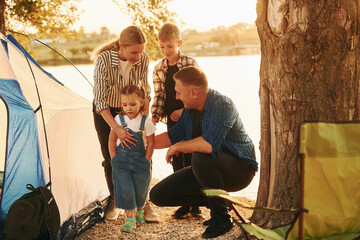 Wall Mural - Beautiful sunlight. Family of mother, father and kids is on the camping