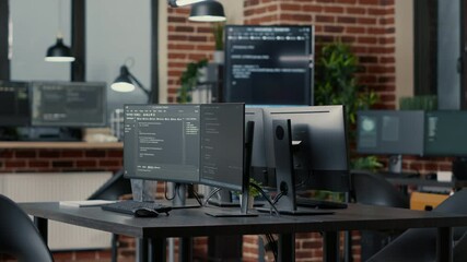 Computer screens running programming code in empty software developing agency office and computers parsing data algorithms in background. Neural network servers cloud computing in data room.