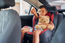 Little Boy With Teddy Bear Is Sitting In The Automobile