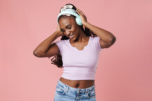 Black Young Woman Smiling While Listening Music With Headphones