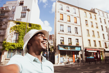 Happy young black man taking selfie in city