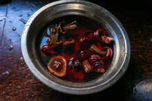 A Pot Of Red Crimini Mushrooms In The Kitchen Is Soaking In Water, Ready For Cooking.