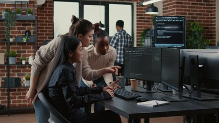 Mixed team of software engineers brainstorming ideas for new code library in front of computer screens compiling algorithms. Diverse app developers collaborating on group project in it agency office.