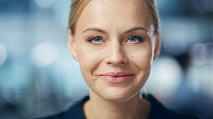 Wall Mural - Portrait of Gorgeous Caucasian Woman with Deep Blue Eyes, Blonde Hair, Perfect Smile. Beautiful Girl Looks up at the Camera Happily. Abstract Bokeh out of Focus Background. Close-up Shot