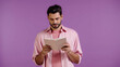 © LIGHTFIELD STUDIOS - young bearded man reading book isolated on purple