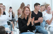 © ASDF - close up. smiling young woman applauding sitting in conference r