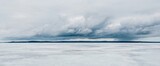 Fototapeta  - Frozen forest lake on a cloudy day. Dramatic sky after a blizzard. Onega, Karelia, Russia.Atmospheric winter landscape. Panoramic view. Nature, climate change, christmas vacations, eco tourism