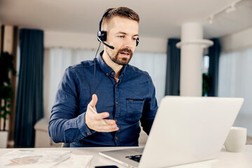 Wall Mural - a focused businessman having an online meeting from his home.