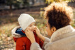 © Dusan Petkovic - A babysitter touching little boy's cheeks outside. Adorable boy getting attention.