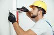 © Kostiantyn - Portrait of male worker professional electrician in uniform installing electrical outlet in apartment after renovation work