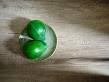 Two Green Papayas On Plate On Wooden Surface