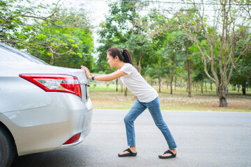 Wall Mural - Asian women Are broken down car. She is pushing the car.