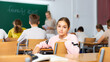 © JackF - Sad young schoolgirl turned around while sitting at desk in classroom and looking at camera.