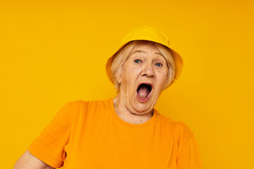 elderly woman in yellow t-shirts hat posing isolated background