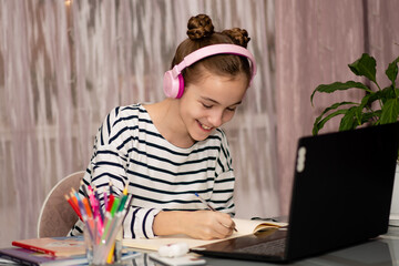 A cute teenage girl studying from home. School. Technology. Education.