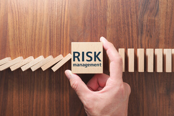 Aufkleber - Concept image of stopping domino effect. Risk management. Putting wood cube and stopping domino.
