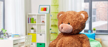 Soft Toys And Childhood Concept - Brown Teddy Bear Over Children's Room Background