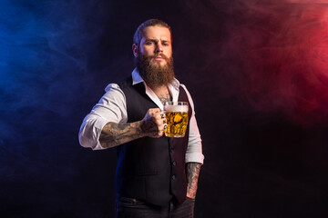 Half length of hipster bearded man who holds mug of beer looking at camera over smoke background