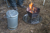 Fototapeta Kwiaty - 冬のキャンプで煙の出る燻製器と焚火