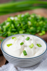 Wall Mural - sour cream with sliced onion on wooden surface