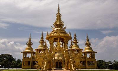 Wall Mural - Chiang Rai, Thailand - Sep 05, 2020 : Elaborate sculptures of golden pagoda at the famous Wat Rong Khun (White Temple) in Chiang Rai, Thailand. Selective Focus.