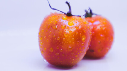 two red fresh tomatoes on a white background