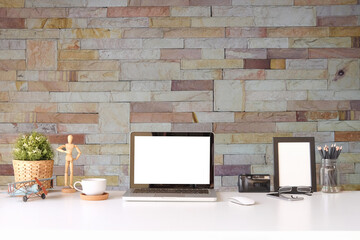 Wall Mural - Mock up computer laptop, camera, coffee cup and wooden frame on white table with brick wall.