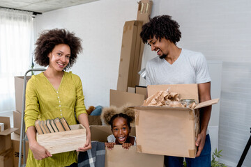 Happy playful African American family moving in new apartment, unpacking, moving stuff, purchase property concept