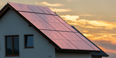 Wall Mural - photovoltaic panels on the roof of the house during a beautiful sunset