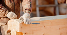 Carpenter Worker With Log Wooden. Woodwork Job, House Frame Building