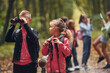 © standret - Group of people. Kids in green forest at summer daytime together