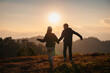 © Mumemories - Young asian couple holding hands enjoying on hill in countryside at sunset