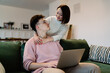© BullRun - Asian woman hug caucasian man with laptop on sofa