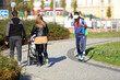 Para młodych ludzi z dzieckiem w wózku spaceruje chodnikiem, alejką we Wrocławiu.