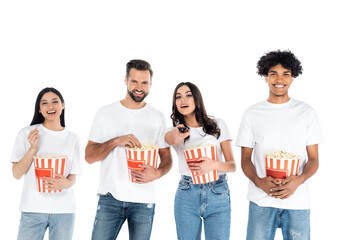 Poster - young woman clicking tv channels near happy multiethnic friends eating popcorn isolated on white.