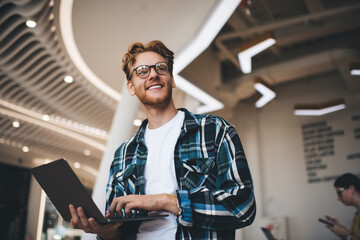 Young caucasian guy using laptop in office space
