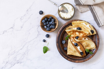 Sticker - Celebrating Pancake day, healthy breakfast. Delicious homemade crepes with blueberries and ricota on a stone tabletop. Top view flat lay. Copy space.