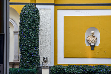 Poster - Details of the courtyard of an ancient palace in the historic centre of Turin, decorated with sculptures and plants illuminated by blue lights, Piedmont, Italy